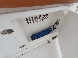 Slide: The Image of Storage compartment on a 2001 Century 3200 Walk-Around boat with coiled blue hose. - 42