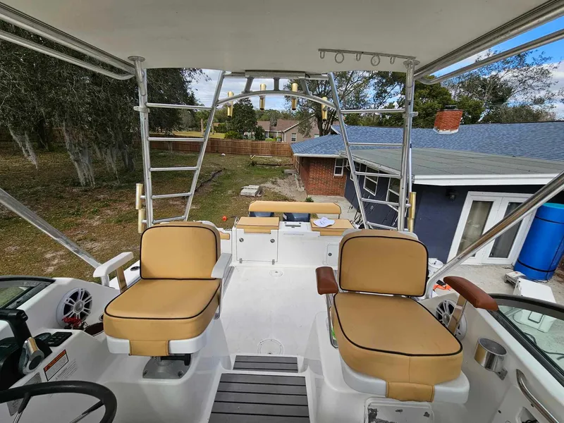 Slide: The Image of 2001 Century 3200 Walk-Around boat interior with tan seats and outdoor view. - 9