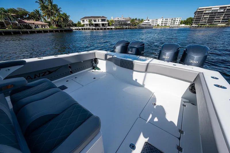 Slide: The Image of Freeman 37 boat, 2019 model, spacious deck with four outboard motors, docked near waterfront homes. - 25