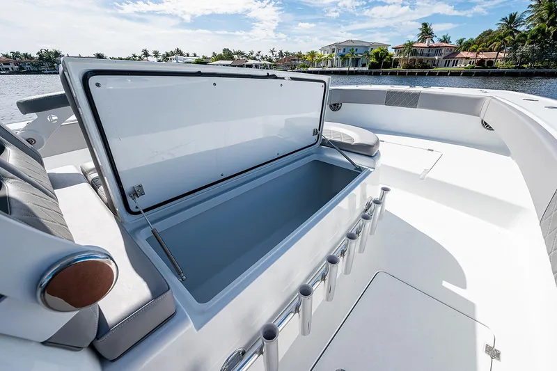 Slide: The Image of 2019 Freeman 37 boat with open storage compartment, docked near waterfront homes. - 27