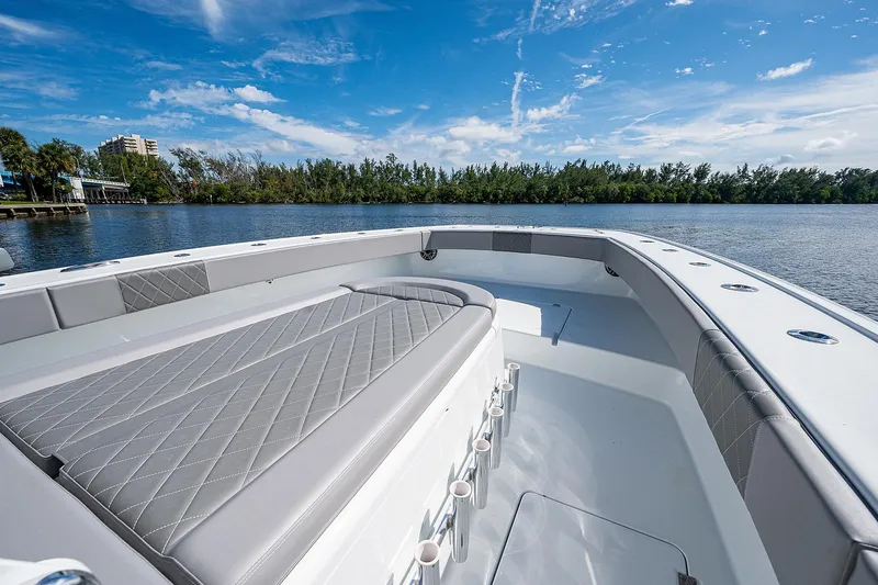 Slide: The Image of 2019 Freeman 37 boat with spacious deck and seating, on a calm lake. - 34