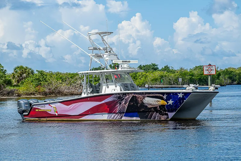 Slide: The Image of Freeman 37 boat with American flag and eagle design, 2019 model, on a calm waterway. - 39