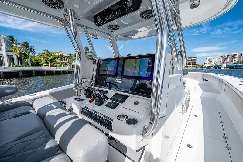 Slide: The Image of Freeman 37 boat cockpit with advanced navigation system, 2019 model, docked by waterfront homes. - 9