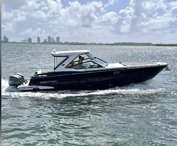 The Image of 2018 Monterey 385 SE boat cruising on a sunny day with city skyline in background. - 0