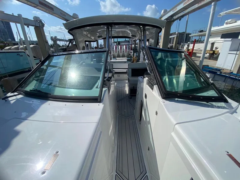 Slide: The Image of 2018 Monterey 385 SE boat with sleek design and spacious deck, docked under clear skies. - 15