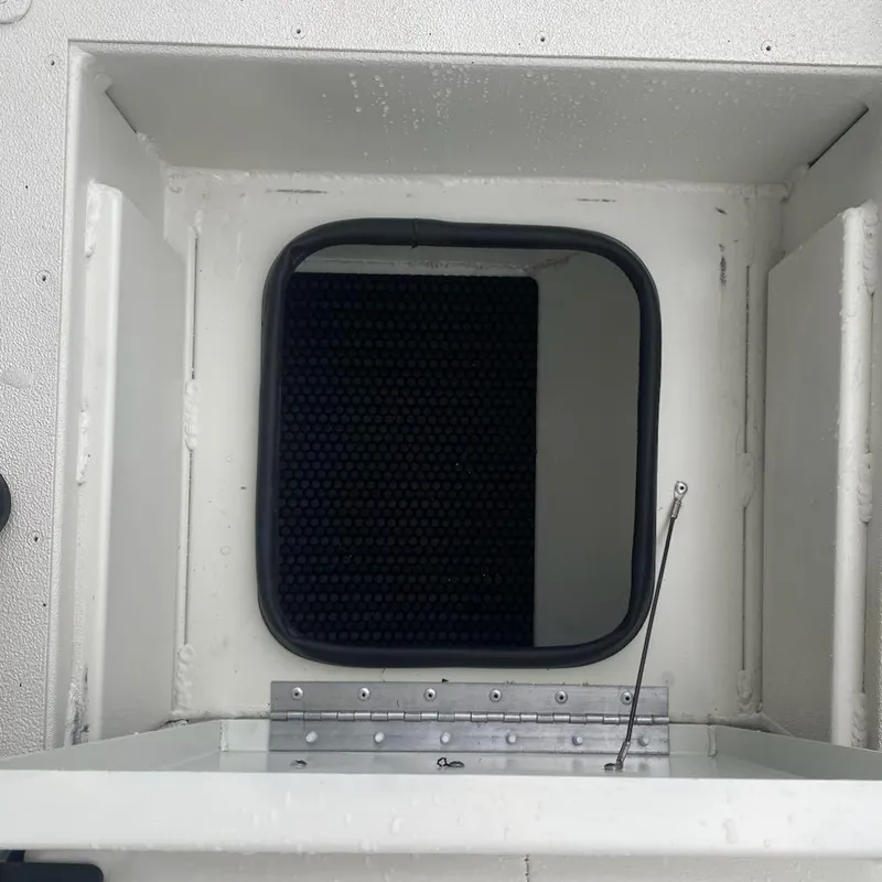 Slide: The Image of 2024 Ranger RB190 boat compartment with open hatch and black interior mat. - 11