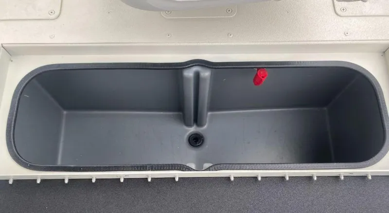 Slide: The Image of 2024 Ranger RB190 boat storage compartment with drain plug and red latch. - 12