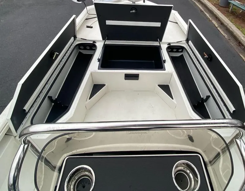 Slide: The Image of 2024 Ranger RB190 boat interior with open storage compartments and cup holders. - 2