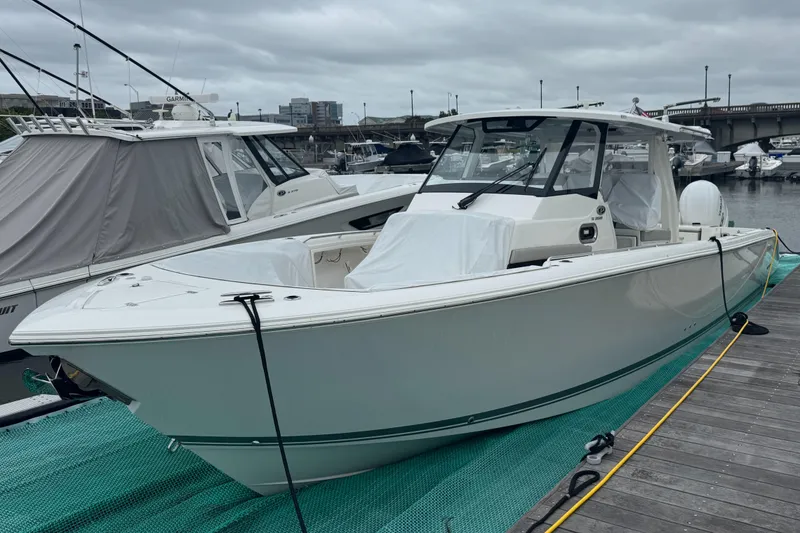 The Image of 2024 Pursuit S 358 Sport boat docked at marina under cloudy sky. - 0