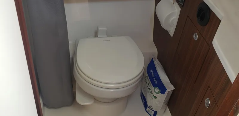 Slide: The Image of 2024 Pursuit S 358 Sport boat bathroom with toilet and wooden cabinetry. - 30