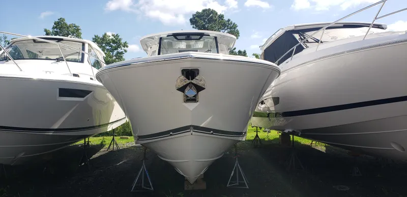 Slide: The Image of 2024 Pursuit S 358 Sport boat front view, docked between two other boats. - 5