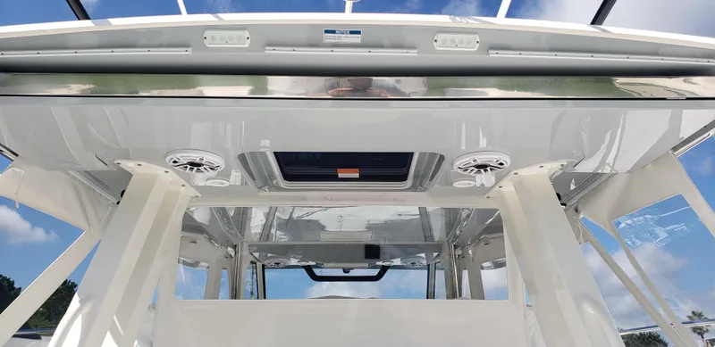 Slide: The Image of 2024 Pursuit S 358 Sport boat interior with speakers and skylight. - 7