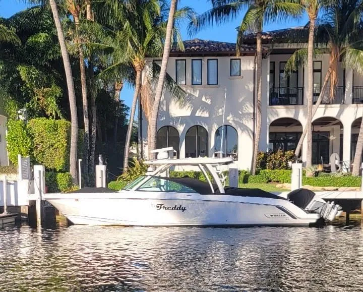 The Image of Boston Whaler 320 Vantage 2021 by a waterfront villa. - 0