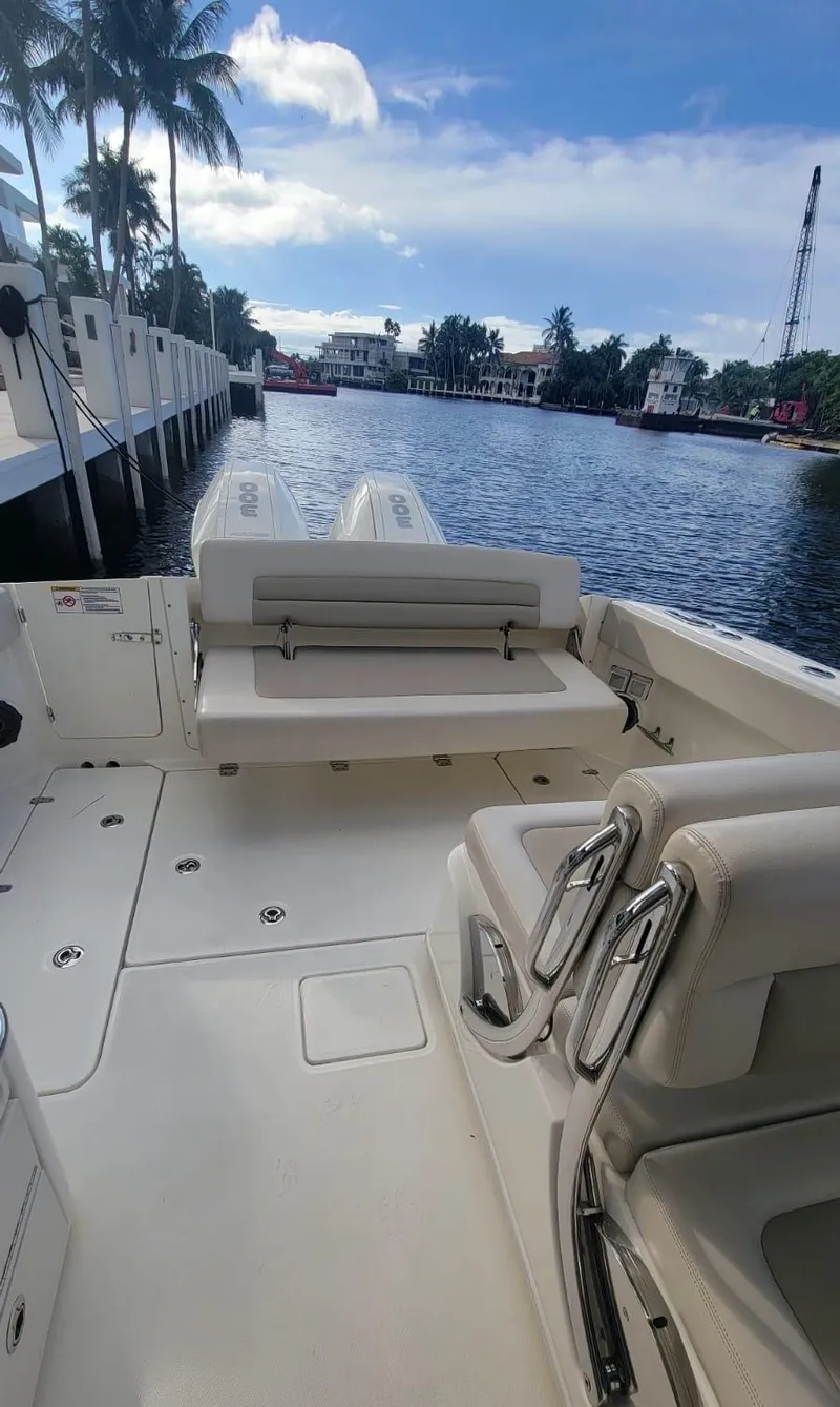 Slide: The Image of Boston Whaler 320 Vantage 2021 on calm water with palm trees in background. - 16