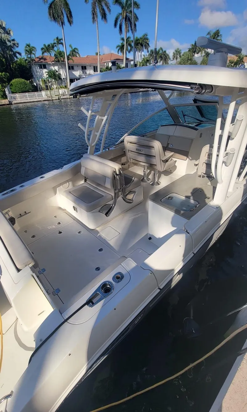 Slide: The Image of Boston Whaler 320 Vantage 2021 by the water with palm trees in the background. - 4