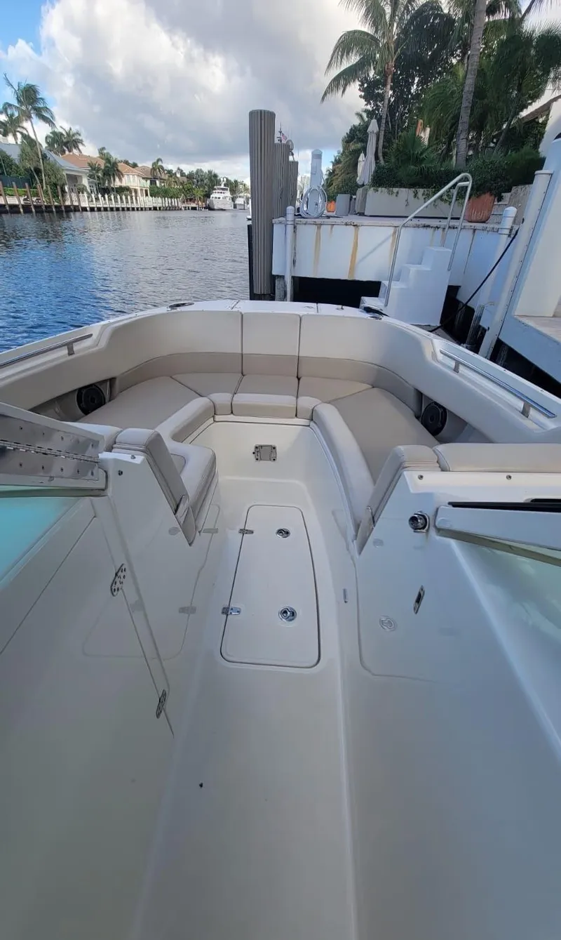 Slide: The Image of Boston Whaler 320 Vantage 2021, luxury boat docked with palm trees in background. - 6