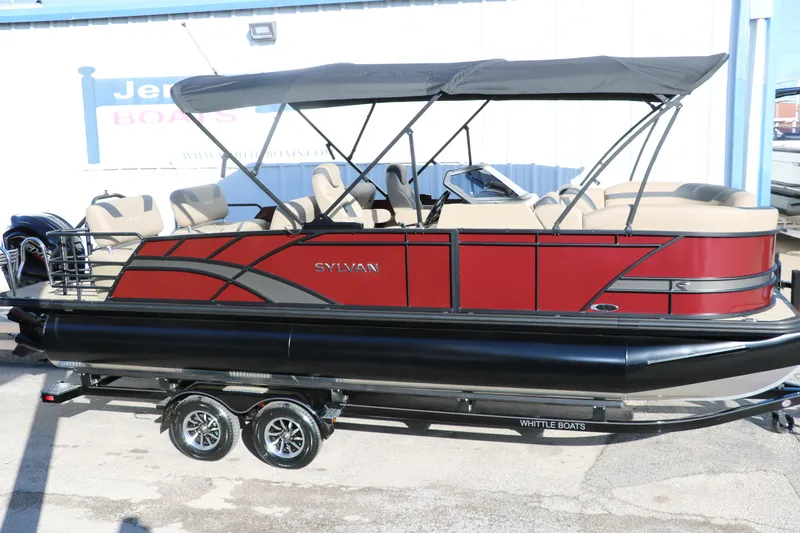 The Image of 2024 Sylvan L3 RLZ pontoon boat with red and black exterior on a trailer. - 0