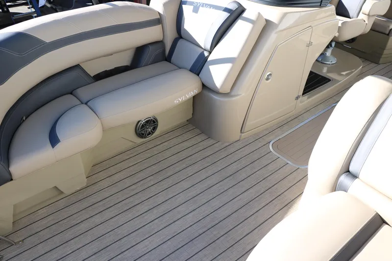 Slide: The Image of 2024 Sylvan L3 RLZ boat interior with beige and gray seating and wood-like flooring. - 15