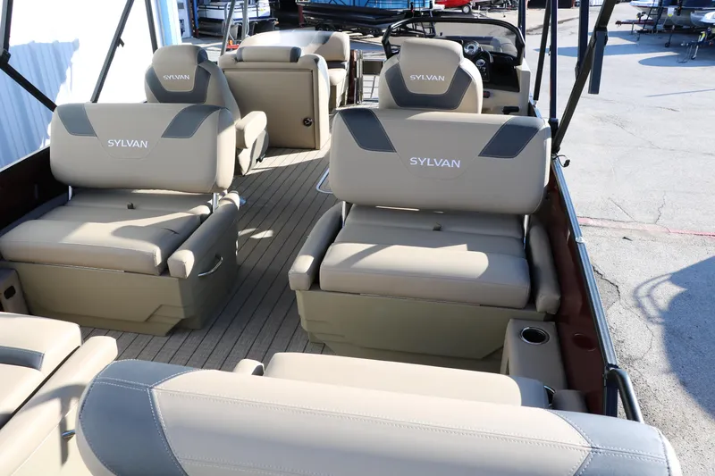 Slide: The Image of 2024 Sylvan L3 RLZ pontoon boat interior with beige seating and modern design. - 16