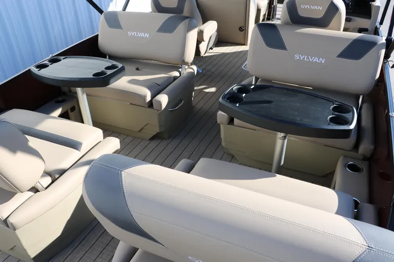 Slide: The Image of 2024 Sylvan L3 RLZ boat interior with beige seating and built-in tables. - 22