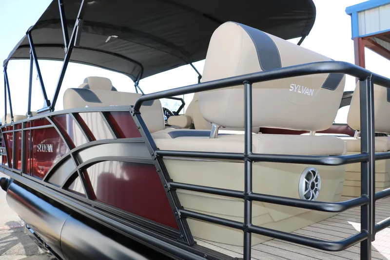 Slide: The Image of 2024 Sylvan L3 RLZ pontoon boat with beige seats and black railing. - 6