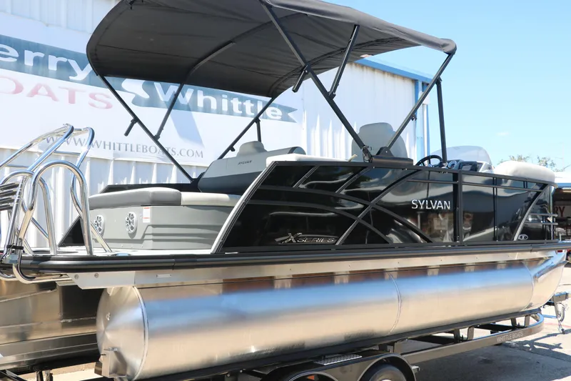 Slide: The Image of 2025 Sylvan X1 CLZ DH Tri-Toon pontoon boat with black canopy. - 2