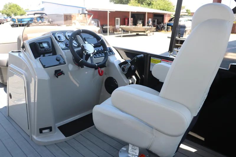 Slide: The Image of 2025 Sylvan X1 CLZ DH Tri-Toon boat cockpit with steering wheel and captain's chair. - 25