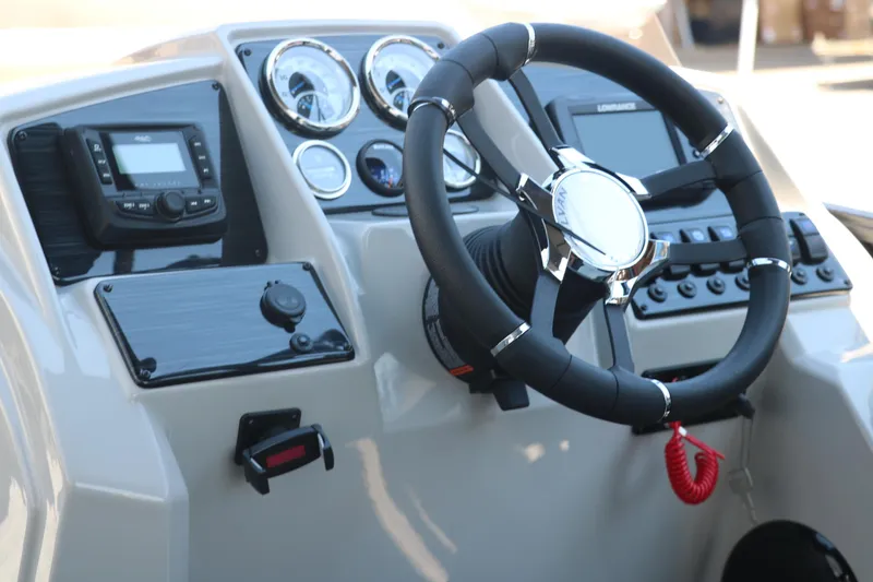 Slide: The Image of 2025 Sylvan X1 CLZ DH Tri-Toon boat dashboard with steering wheel and control panel. - 27