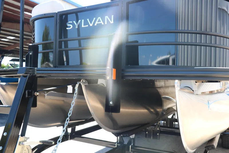Slide: The Image of 2025 Sylvan X1 CLZ DH Tri-Toon boat front view in a marina. - 9