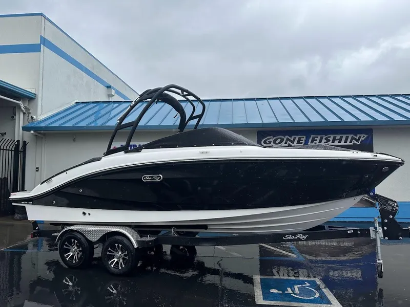 Slide: The Image of 2024 Sea Ray SPX 210 boat on a trailer outside a dealership. - 1