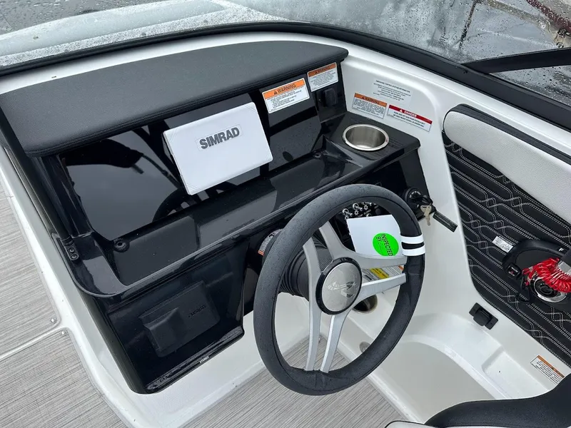 Slide: The Image of 2024 Sea Ray SPX 210 boat dashboard with Simrad display and steering wheel. - 15