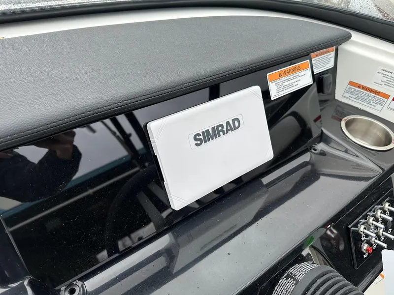 Slide: The Image of 2024 Sea Ray SPX 210 dashboard with Simrad display and warning labels. - 17