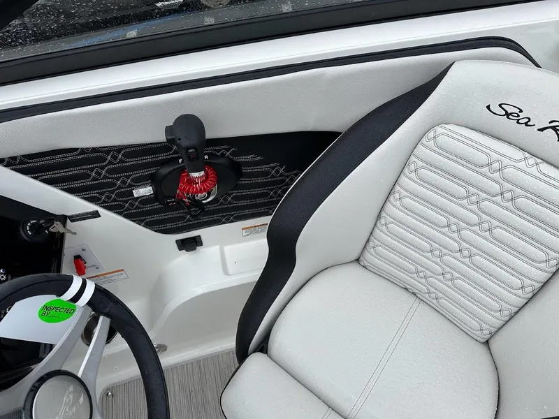 Slide: The Image of Interior of 2024 Sea Ray SPX 210 boat, featuring a white and black captain's seat. - 18