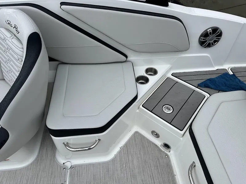 Slide: The Image of 2024 Sea Ray SPX 210 boat interior with seating, cup holders, and storage compartments. - 20