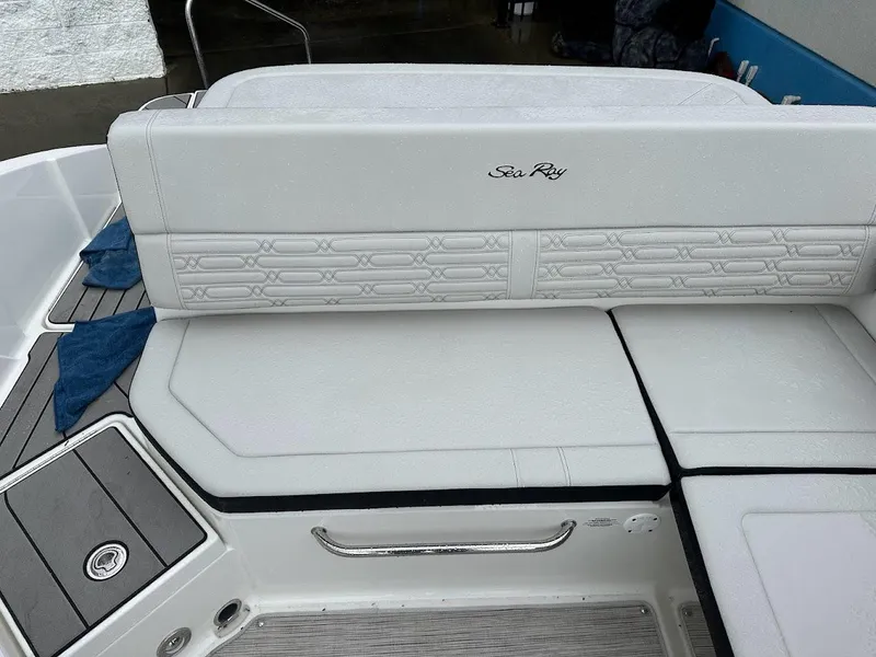 Slide: The Image of 2024 Sea Ray SPX 210 boat with white cushioned seating and deck. - 21