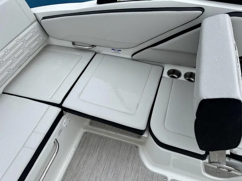 Slide: The Image of 2024 Sea Ray SPX 210 boat interior with white cushioned seating and cup holders. - 22