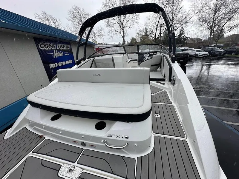 Slide: The Image of 2024 Sea Ray SPX 210 boat with white seating and gray deck in a marina. - 7