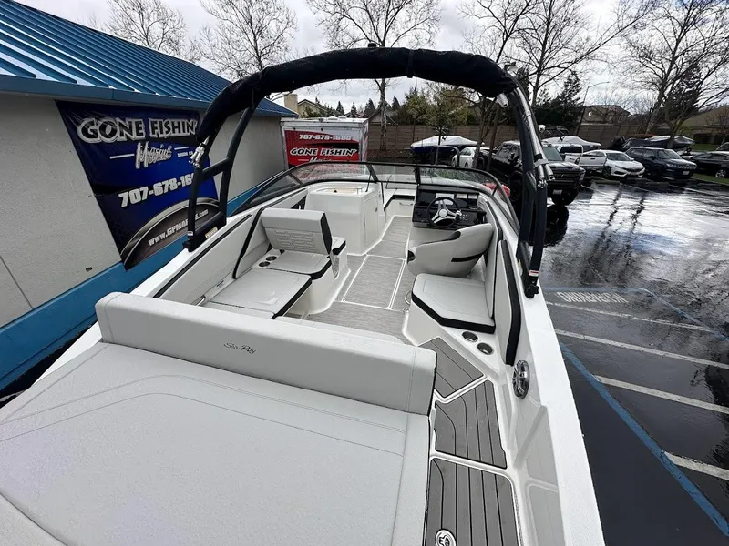 Slide: The Image of 2024 Sea Ray SPX 210 boat interior at dealership on a rainy day. - 9