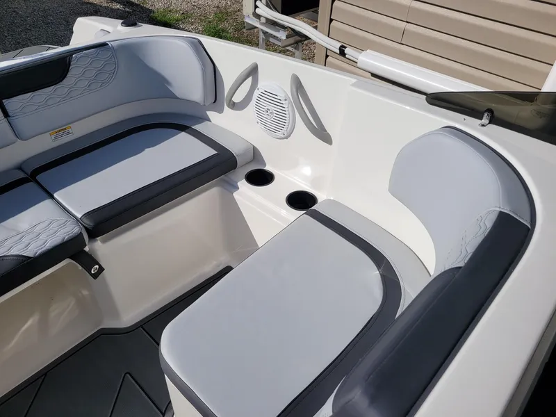 Slide: The Image of 2024 Bayliner M17 boat interior with cushioned seating and cup holders. - 6