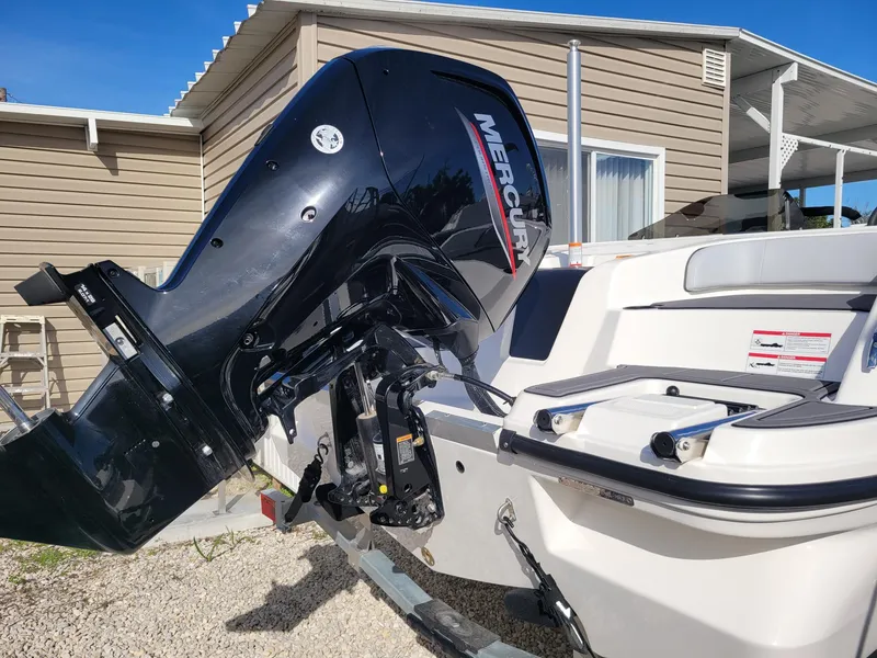 Slide: The Image of 2024 Bayliner M17 boat with Mercury outboard motor in a residential setting. - 8