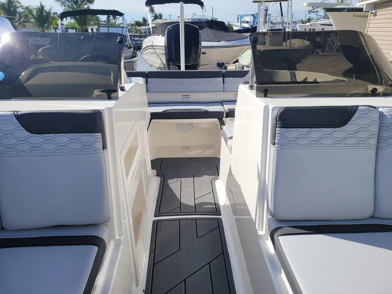 Slide: The Image of 2024 Bayliner M17 boat interior with seating and dashboard, docked at marina. - 9