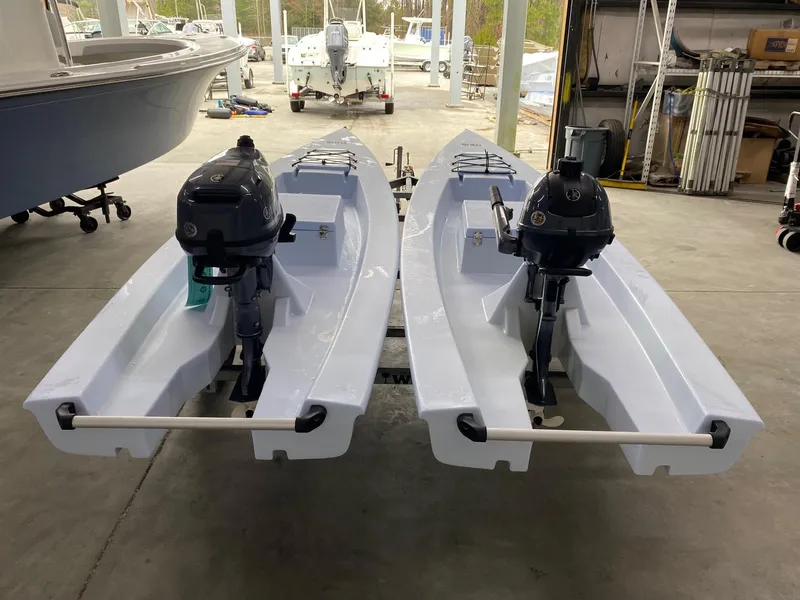 Slide: The Image of Two 2025 Solo Skiff 145 boats with outboard motors in a storage area. - 4