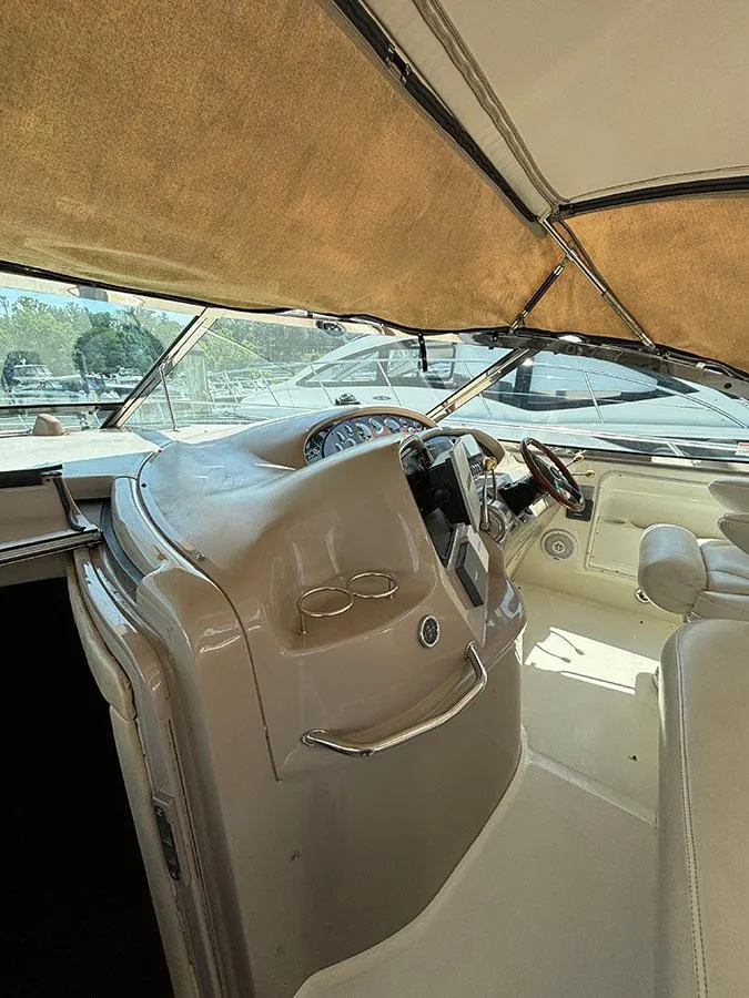 Slide: The Image of 2001 Sea Ray 410 Sundancer helm station with beige interior and steering wheel. - 11