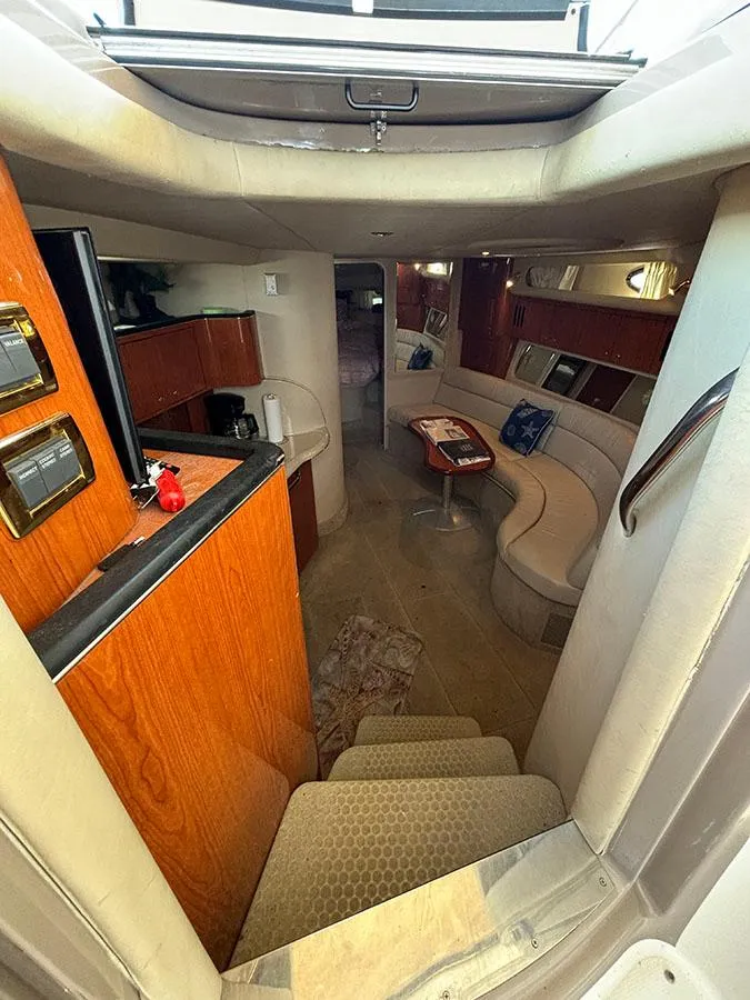 Slide: The Image of Interior of 2001 Sea Ray 410 Sundancer yacht with cozy seating and wooden cabinetry. - 12