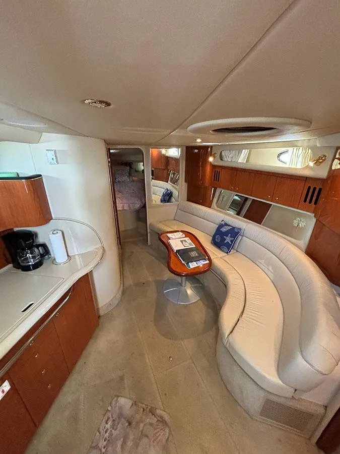 Slide: The Image of Interior of 2001 Sea Ray 410 Sundancer yacht with curved seating and kitchenette. - 13