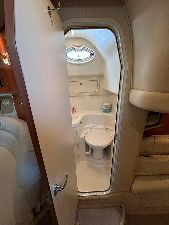 Slide: The Image of 2001 Sea Ray 410 Sundancer bathroom interior with toilet and porthole window. - 15