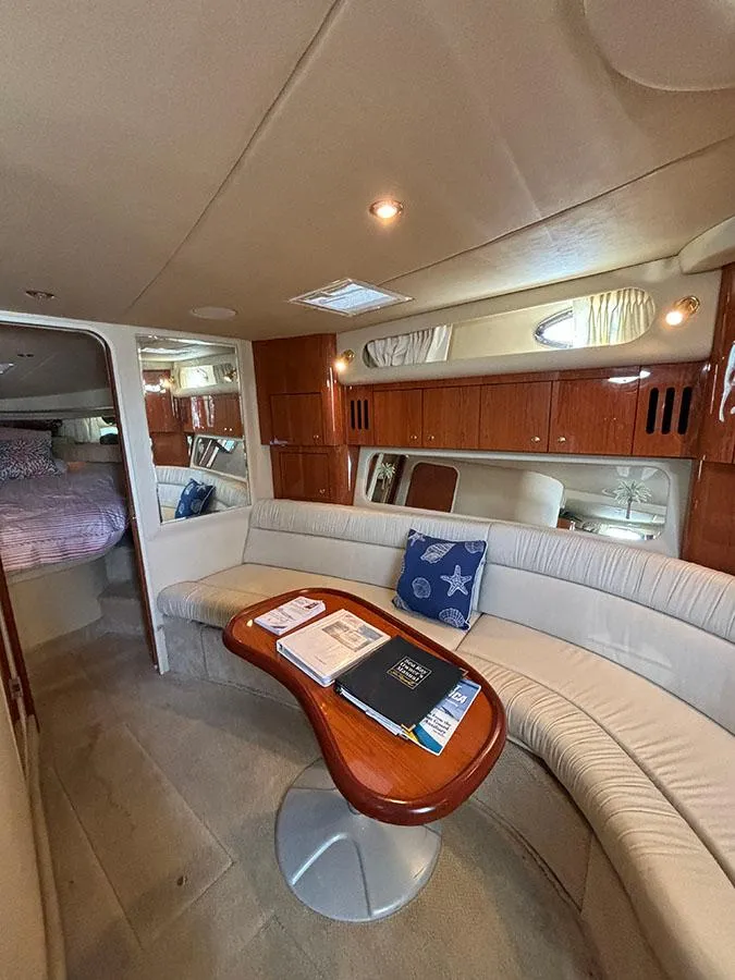 Slide: The Image of 2001 Sea Ray 410 Sundancer interior with curved seating and wooden table. - 17