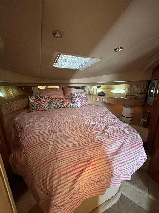 Slide: The Image of 2001 Sea Ray 410 Sundancer cabin with cozy bed and striped bedding. - 19