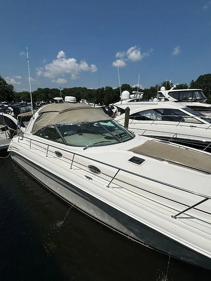 Slide: The Image of 2001 Sea Ray 410 Sundancer yacht docked in a marina on a sunny day. - 2