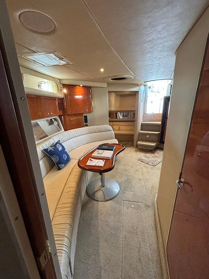 Slide: The Image of 2001 Sea Ray 410 Sundancer interior with curved seating and wooden table - 23